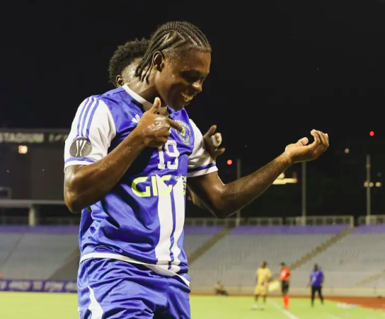 Warner Brown celebrates after opening the scoring for Mt. Pleasant FA in the 5th minute. Mt Pleasant FC players celebrating a goal against Defense Force in Caribbean Cup semi-final