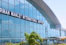 JAMAICA-Norman Manley International waives landing and parking fees. Norman Manley International Airport terminal with passengers and waived fees announcement