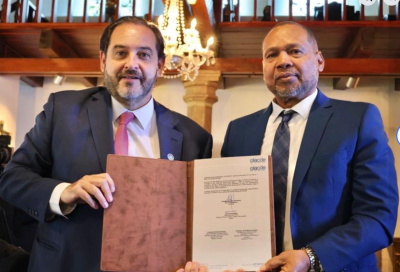 OCLADE-new-secretary Dr Leroy Almendarez CEO of Belize Ministry of Public Utilities addresses OLACDE leadership transition ceremony endorsing re-election of Executive Secretary Andrés Rebolledo Smitmans for 2026-2029 term