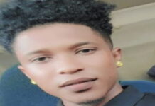 GUYANA-Court awards multi-million dollar compensation to a youth who was unlawfully arrested. Youth standing outside Guyana courthouse with legal papers after compensation ruling