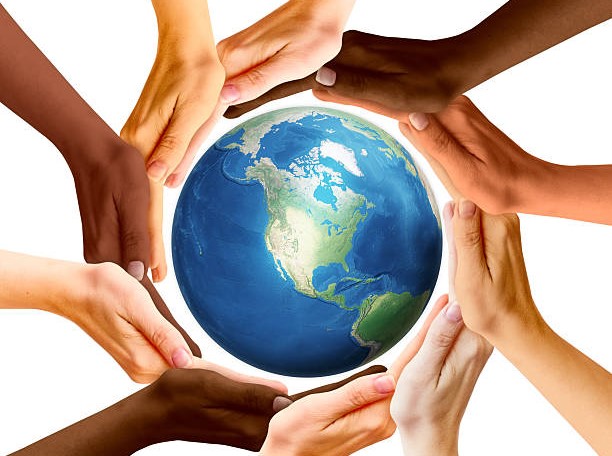 Multiracial human hands and Earth planet