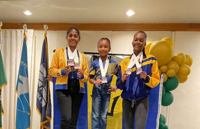 Barbados chess champions Clarke and Wilson with medals at CAC festival.