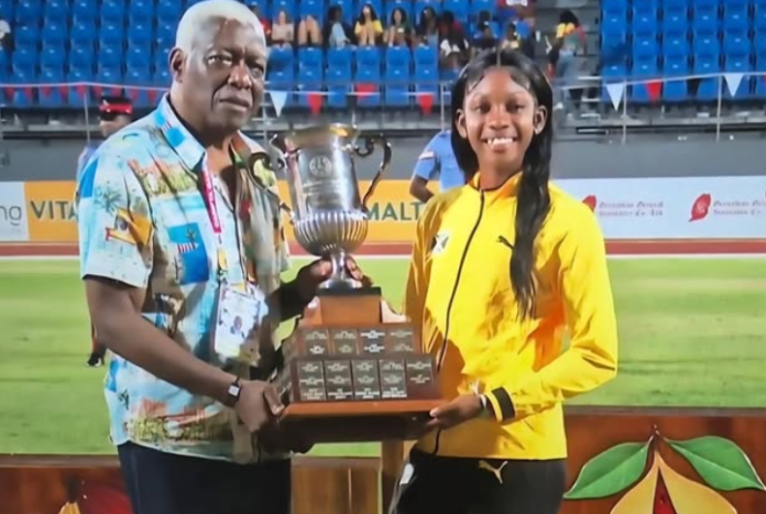 Austin-Sealy1 Jamaican team celebrating with 40th CARIFTA trophy as Douglas holds Austin Sealy Award