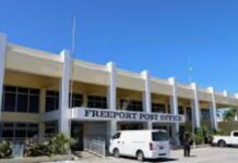 BAHAMAS-Government says Post Office Bank will not close. Bahamas government official at podium confirming Post Office Bank remains open