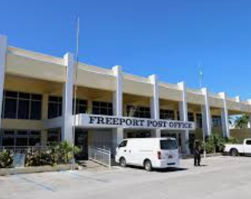 Bahamas-Savings-bank Bahamas government official at podium confirming Post Office Bank remains open