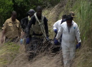 BELIZE-Police awaiting autopsy as body of second missing person found. Belize police officers near scene where second missing person's body was discovered