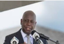 BAHAMAS-PM Davis urges Bahamians to put country before politics. Prime Minister Davis speaking at podium with Bahamian flag