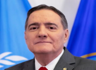 CARIBBEAN-PAHO director warns of the “escalating surge” of dengue and other diseases. PAHO director speaking at podium with dengue prevention charts in background