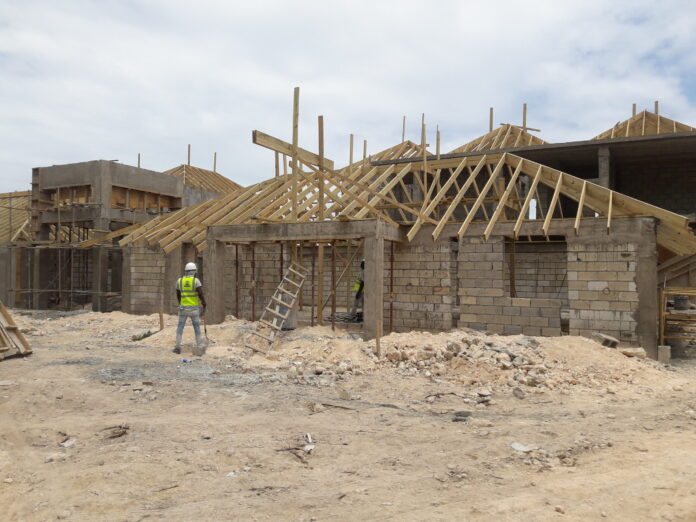Hardware store shelves with price tags showing increased costs for construction supplies