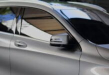 GUYANA-Government warns motorists about falsifying new tint regulations. Guyana police officer inspecting car window tint during traffic stop