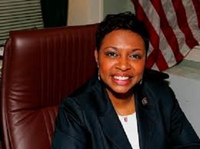 Clarke Caribbean-American congresswoman speaking at press conference with Voting Rights Act document