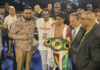 BOXING-Dharry creates history by winning the IBO World title. Elton Dharry holding IBO world title belt in ring with crowd cheering