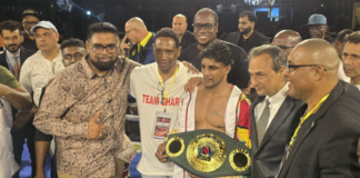 BOXING-Dharry creates history by winning the IBO World title. Elton Dharry holding IBO world title belt in ring with crowd cheering