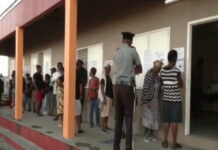 ANTIGUA-Antiguans voting for a new government. Antigua citizens casting ballots at polling station with national flags
