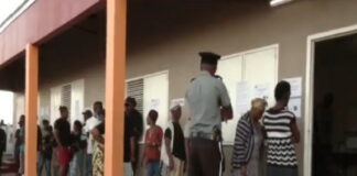 ANTIGUA-Antiguans voting for a new government. Antigua citizens casting ballots at polling station with national flags