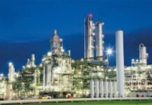 TRINIDAD-Government urged to make a statement on the possible shutdown of the methanol producer. Industrial plant exterior with "Methanol Producer" sign and empty parking lot